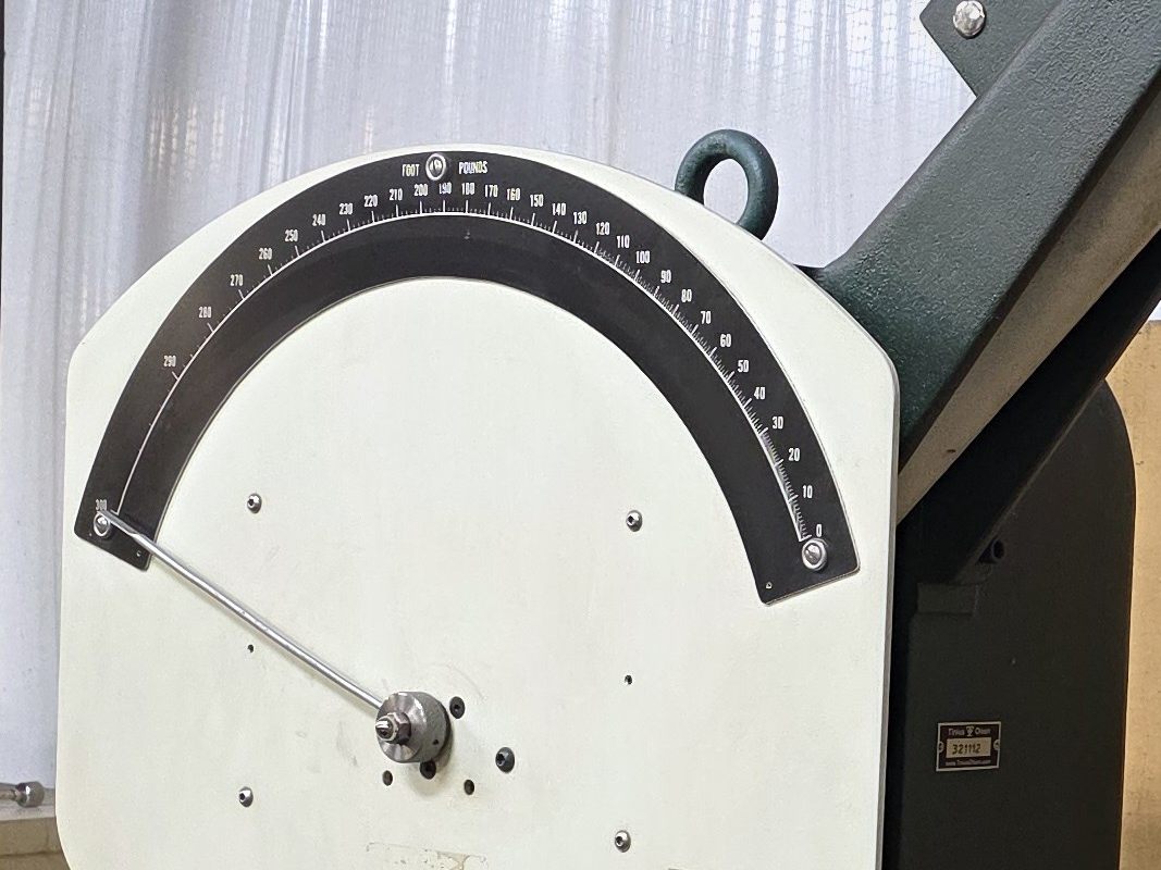 Impact tester dial graduated in foot pounds from zero to 300