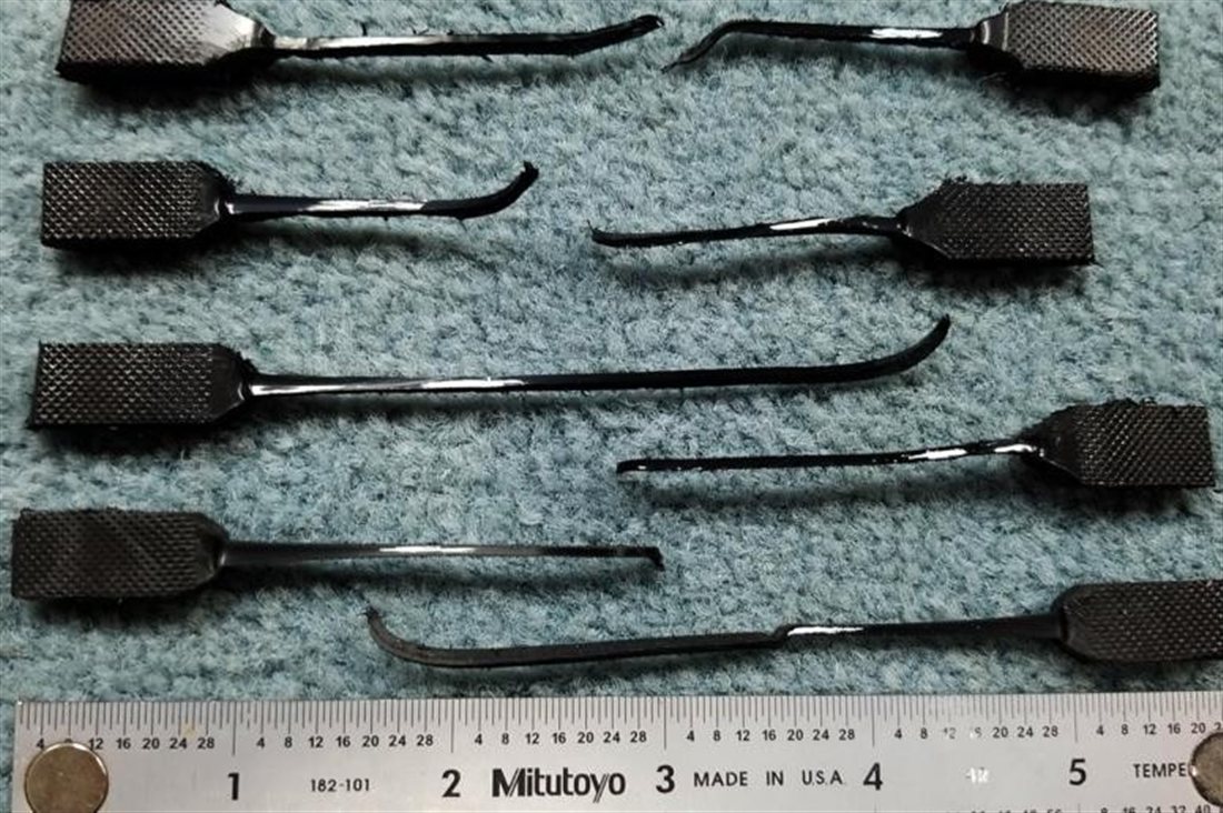 HDPE tensile specimens pulled to failure, showing necking and drawing